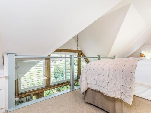 a bedroom with a bed and a large window at Pass the Keys Peaceful And Beautiful Barn In Downland Village in Chichester