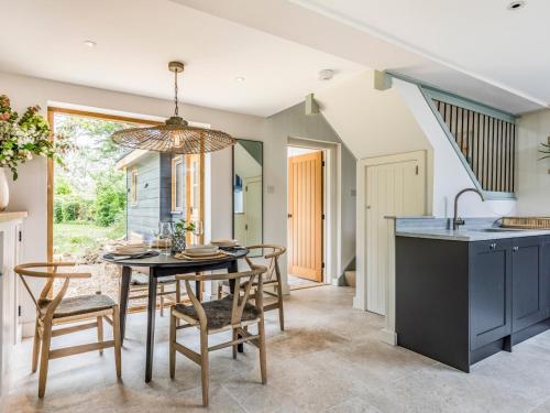 a kitchen and dining room with a table and chairs at Pass the Keys Peaceful And Beautiful Barn In Downland Village in Chichester