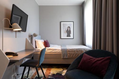 a bedroom with a bed and a desk and a chair at Elite Palace Hotel & Spa in Stockholm