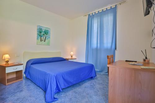 a bedroom with a blue bed and a window at Villaggio Selene Mare in Paestum