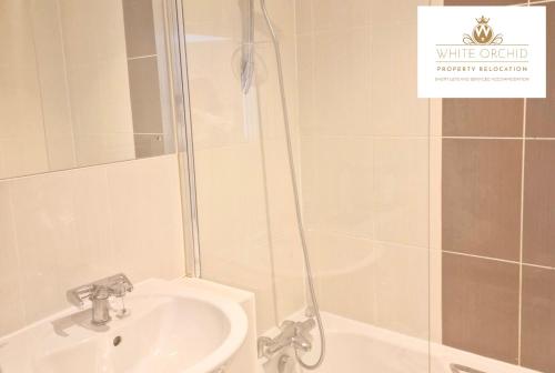 y baño con ducha, lavabo y bañera. en Corporate 2Bed Apartment with Balcony & Free Parking Short Lets Serviced Accommodation Old Town Stevenage by White Orchid Property Relocation, en Stevenage