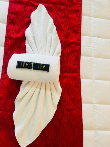 a white bandanna on top of a red blanket at Monument Motor Lodge Papakura in Auckland