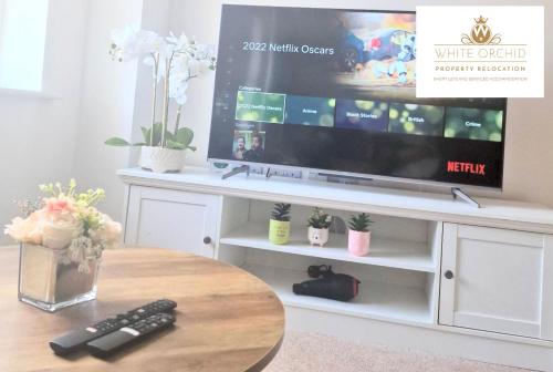 a living room with a tv and a table at Contractors 2Bedrooms Apartment with Balcony & Free Parking by White Orchid Property Relocation in Stevenage