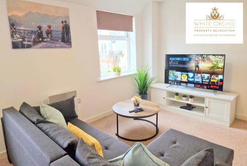 a living room with a couch and a tv at Contractors 2Bedrooms Apartment with Balcony & Free Parking by White Orchid Property Relocation in Stevenage
