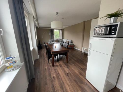 cocina y sala de estar con mesa y nevera en TopSleep Apartment 26-1, en Arnhem