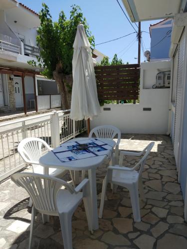 a table and chairs and an umbrella on a patio at Alpha apartment, Ireon Samos in Iraion