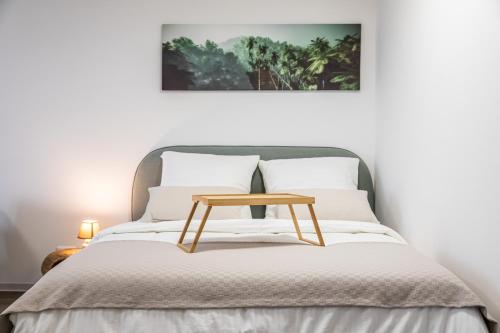 a bed with a wooden table on top of it at Modern Studio good located Balcony King Bed in Frankfurt