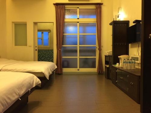 冬山鄉的住宿－松舍民宿，酒店客房设有两张床和窗户。