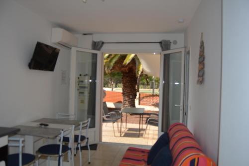 - un salon avec une porte s'ouvrant sur une terrasse dans l'établissement rêve méditerranéen, La vie est belle, au Barcarès