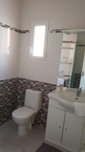 une salle de bain avec toilettes, lavabo et fenêtre dans l'établissement rêve méditerranéen, La vie est belle, au Barcarès