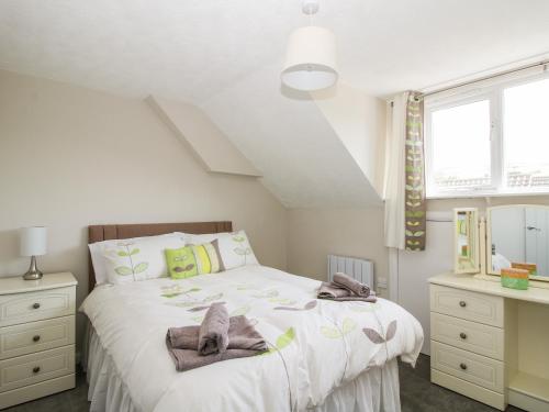 a bedroom with a bed with towels on it at Rosemary Cottage in Craven Arms