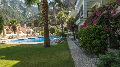 a resort yard with a swimming pool and palm trees at dolphine apatment turunç in Marmaris