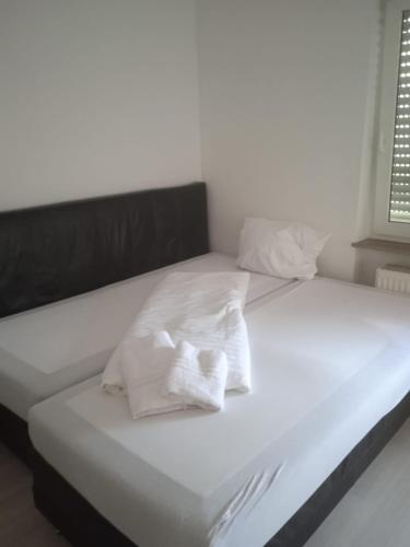 Una cama blanca con dos almohadas. en 3 Zimmer Wohnung en Kaiserslautern
