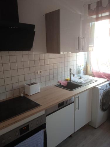 a kitchen with a sink and a washing machine at 3 Zimmer Wohnung in Kaiserslautern
