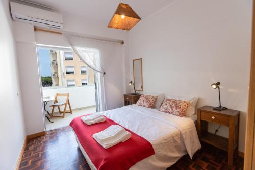 a bedroom with a large bed with a red blanket at Sun & Beach Apartment by Soulplaces in Costa da Caparica