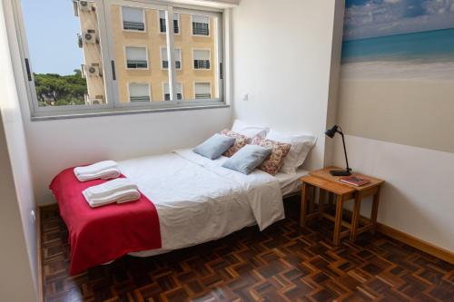 a small bedroom with a bed and a window at Sun & Beach Apartment by Soulplaces in Costa da Caparica