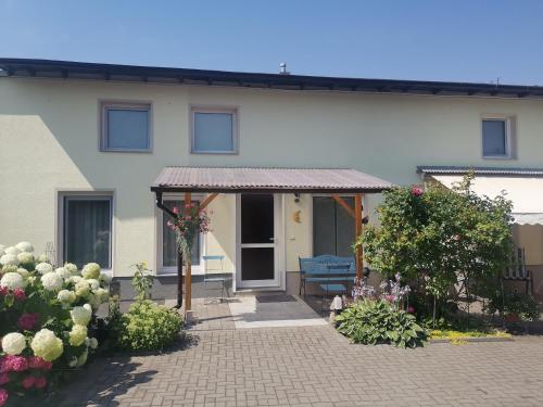 ein Haus mit einer Veranda und Blumen davor in der Unterkunft Ferienwohnung Uenglingen in Stendal