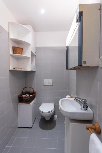 a white bathroom with a toilet and a sink at Sun & Beach Apartment by Soulplaces in Costa da Caparica