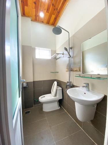 a bathroom with a toilet and a sink at Jolie Maison Đà Lạt in Da Lat