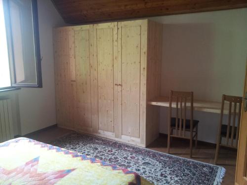 a bedroom with a cabinet and a bed and a window at I Tre Ciliegi Apartment in Sant'Omobono Terme