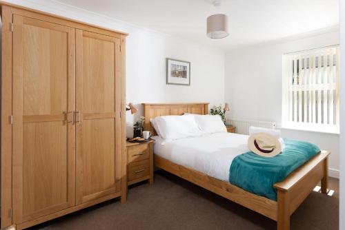 a bedroom with a bed and a wooden cabinet at Rosebud in Portreath