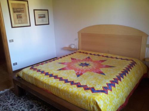 a bedroom with a bed with a quilt on it at I Tre Ciliegi Apartment in Sant'Omobono Terme