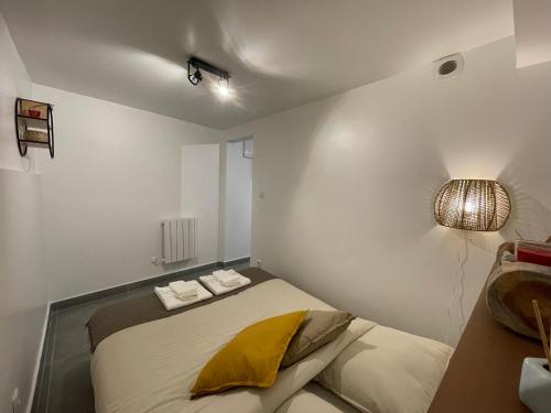 a small bedroom with a bed and a lamp at Grand studio tout équipé proche Paris & Disneyland in Ozoir-la-Ferrière