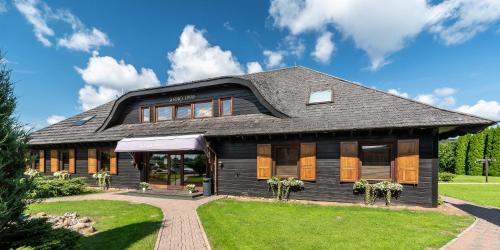 a black house with a gambrel roof at Aparjods in Sigulda