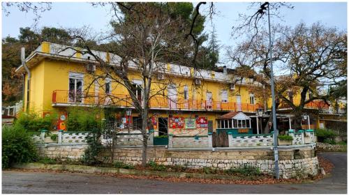 una casa amarilla con una valla delante de ella en B&B&Beer, en Cassano delle Murge