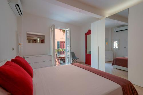 una camera da letto con un grande letto bianco con cuscini rossi di A un passo da Lucio a Bologna