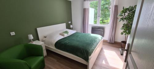 サン・ペ・シュル・ニヴェルにあるGîte Mendi Uraのベッドルーム1室(ベッド1台、緑の椅子付)