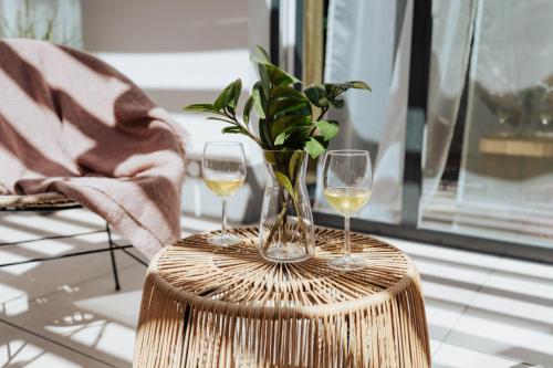a table with two glasses of wine and a plant at JUMBO APARTMENTS in Rajecké Teplice