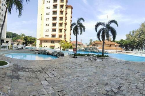 a resort with a pool and a building at NurIzz Condostay Homestay Pantai Puteri Melaka in Kampong Bukit Darat