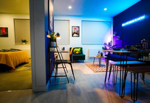 Luxury Stevenage Town Centre Apartment في ستيفنيج: غرفة معيشة مع طاولة وكراسي في غرفة