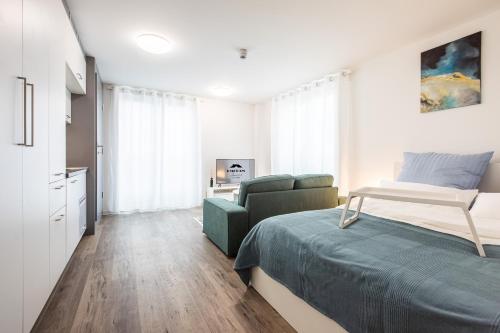 een slaapkamer met een bed en een bank bij Modern Studio and good located in Frankfurt am Main