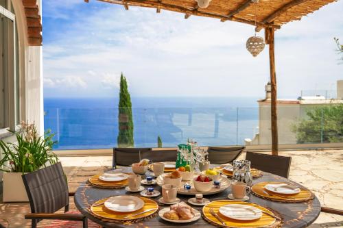 una mesa con comida en el patio en Villa Mimina - Exclusive villa with garden, Jacuzzi and sea view en Praiano