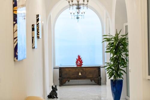 a hallway with a chandelier and a large window at Villa Mimina - Exclusive villa with garden, Jacuzzi and sea view in Praiano