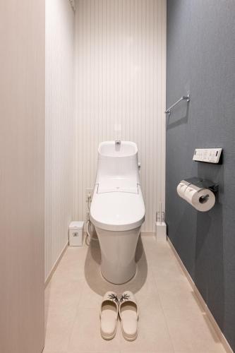 a bathroom with a toilet and a pair of slippers at T・Kスクエア鹿児島中央 in Kagoshima