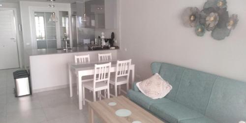 uma sala de estar com um sofá, uma mesa e uma cozinha em Isla Canela Apartamento nuevo en primera línea de playa con vistas al mar em Isla Canela