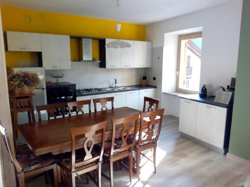 a kitchen and dining room with a table and chairs at Appartamenti Sasso Rosso in Commezzadura