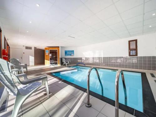 une grande piscine avec deux chaises et une table dans l'établissement T2 bis duplex 6 couchages situé aux BOTTIERES, à Saint-Pancrace