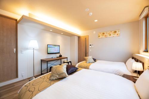 Кровать или кровати в номере T・Kスクエア鹿児島中央
