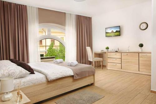 a bedroom with a bed and a desk and a table at Centar lux 2 in Zrenjanin