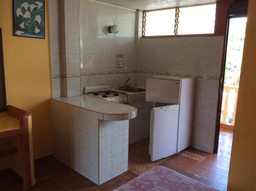 una piccola cucina con piano cottura e frigorifero di Hotel Olimar ad Acapulco