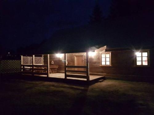 a small wooden cabin with two benches at night at Dom z bali. Chata Michal. in Białowieża