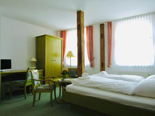 a hotel room with a bed and a desk and a desk at Pension Hexenkessel in Wernigerode