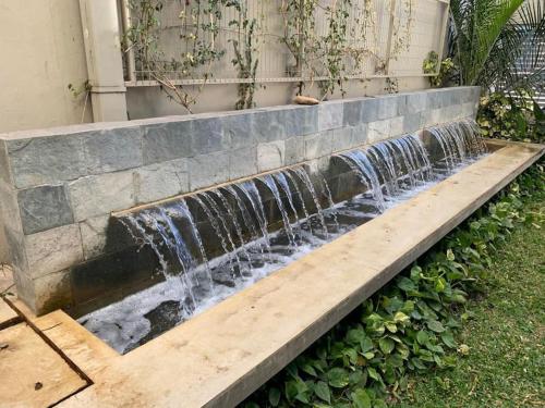 a stone bench with a waterfall in a yard at Monoambiente céntrico in Santa Fe