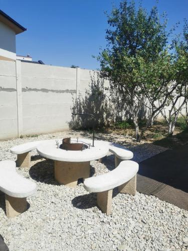 a group of benches sitting around a table at Edit Vendégház in Tiszaújváros