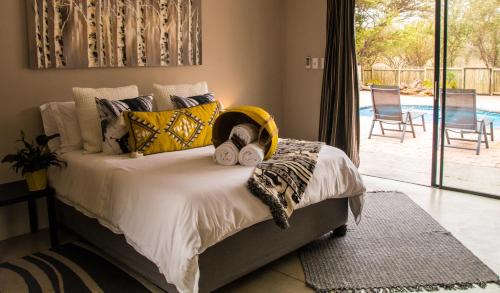 a bedroom with a bed with pillows and a patio at Sentosa Place in Hoedspruit