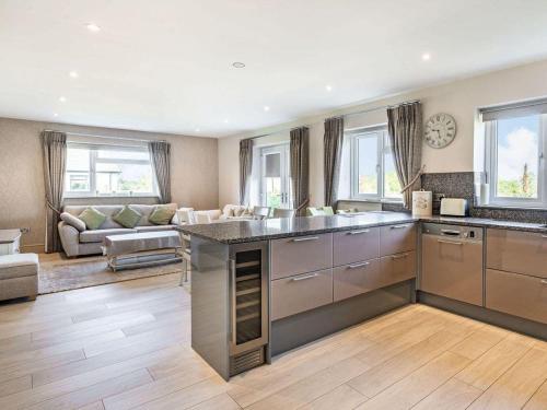 a kitchen with stainless steel appliances and a living room at Beeches Cottage in Blackburn